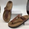Sandalias de cuero marrón con suela de corcho, ideales para uso diario y comodidad. Diseño clásico con tira entre los dedos y hebilla ajustable.