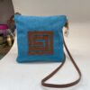 Bolso cruzado de tela azul con diseño marrón en forma de espiral, ideal para uso diario y accesorios de moda.