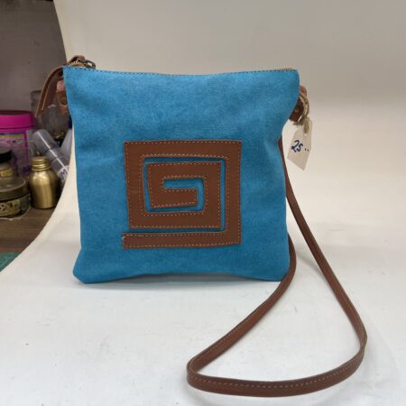 Bolso cruzado de tela azul con diseño marrón en forma de espiral, ideal para uso diario y accesorios de moda.