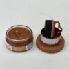 Tarro de crema de chocolate con tapa, acompañado de un aplicador en forma de taza. Ideal para postres y repostería.