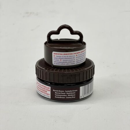 Tarros de crema de tratamiento, uno más pequeño apilado sobre otro, con etiquetas en español que indican su uso y advertencias.